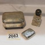 A silver box on legs hall marked for Birmingham, a silver snuff box and a silver topped bottle.