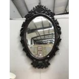 A large bevel edged mirror with heavy ornate frame
