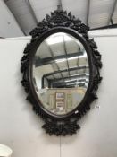 A large bevel edged mirror with heavy ornate frame