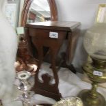 A small drop leaf table with leather top.