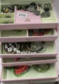 A mixed lot of costume jewellery in a pink jewellery box.