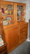 A beech bookcase with glazed top and cupboard/drawer base