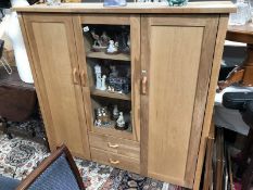 A teak wood cabinet with central glazed display case