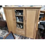 A teak wood cabinet with central glazed display case