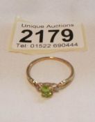 A 9ct gold ring set peridot and small shoulder diamonds.