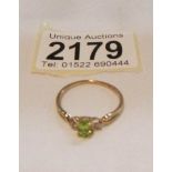 A 9ct gold ring set peridot and small shoulder diamonds.