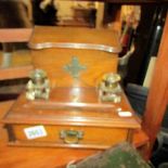 An oak stationary desk cabinet with 2 inkwells.