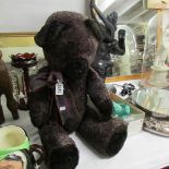 A large dark purple / black teddy bear with growler