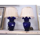 A pair of blue glass vase shaped table lamps with fabric shades