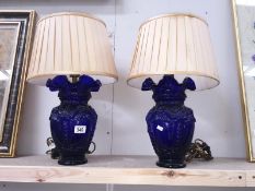 A pair of blue glass vase shaped table lamps with fabric shades