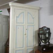 A painted freestanding corner cupboard.