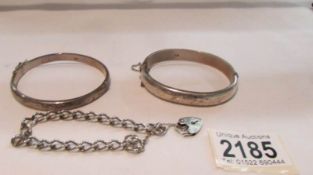 2 silver bangles and a silver wrist chain with lock.