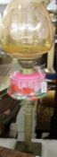 A Victorian brass Corinthian column oil lamp with pink glass font complete with shade and chimney,