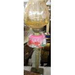 A Victorian brass Corinthian column oil lamp with pink glass font complete with shade and chimney,