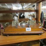 An oak stationary desk tidy featuring inkwells, pen stand and bell.