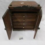 An oak jewellery cabinet with 4 drawers.