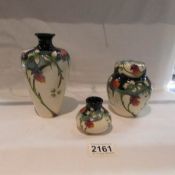 A matching set of 3 Moorcroft items being a vase, a lidded pot and a miniature squat vase.