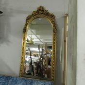 A superb quality bevel edged arched top mirror in ornate gilded frame, 140 cm tall x 49 cm wide.