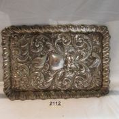 A silver tray embossed with birds and flowers.