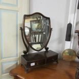 A mahogany shield shaped mirror with drawer.