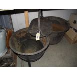 2 cast iron cauldrons on a stand and a hot plate