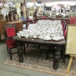 An early 20th century oak Jacobean style extending dining table and 6 dining chairs.