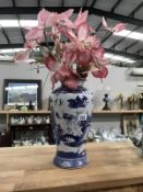 A blue & white Willow pattern vase with artificial flowers