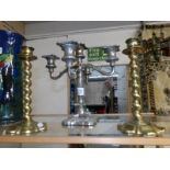 A pair of brass candlesticks and a silver plate candelabra.