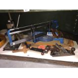 A shelf of woodworking tools including a Mitre saw with spare blades,