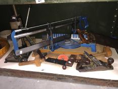 A shelf of woodworking tools including a Mitre saw with spare blades,