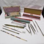 A collection of vintage stationery items including sealing wax sticks, dip pens, propelling pencils,