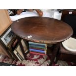 An oval carved side table with under gallery