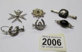 4 silver brooches and 2 silver stars.