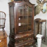 A bombe front display cabinet with 3 drawers and glazed doors.