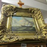 An ornate gilt framed nautical scene.