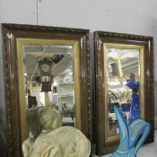 A pair of framed bevel edged mirrors.