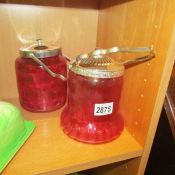 2 cranberry glass biscuit barrels.