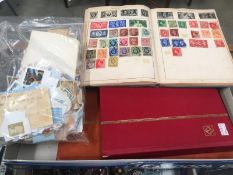 3 albums/stock books of assorted stamps and a bag of loose stamps.