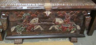A carved chest with metal fittings.