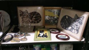 A shelf of miscellaneous items including framed and glazed embroidery.