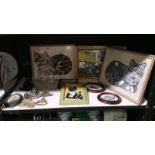 A shelf of miscellaneous items including framed and glazed embroidery.
