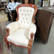 A mahogany framed gentleman's chair with cream upholstery.