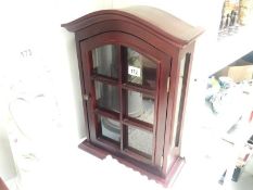 A small darkwood stained display cabinet