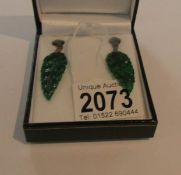 A pair of drop earring set with jade in the form of leaves set emeralds and diamonds.