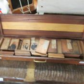 A mahogany gun case containing wood sample blocks.