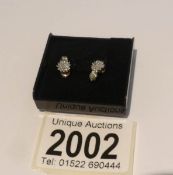 A pair of gold and diamond cluster earrings.