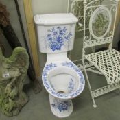 A blue and white toilet complete with cistern.