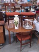 A retro circular drop leaf table and 4 chairs.