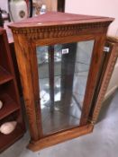 An oak corner cabinet with mirrored back