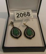 A pair of gold and silver drop earrings set with jade, onyx and diamonds.